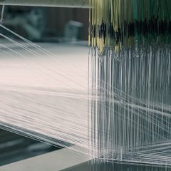 丹後産地の職工部で織りの経て糸を継ぐ